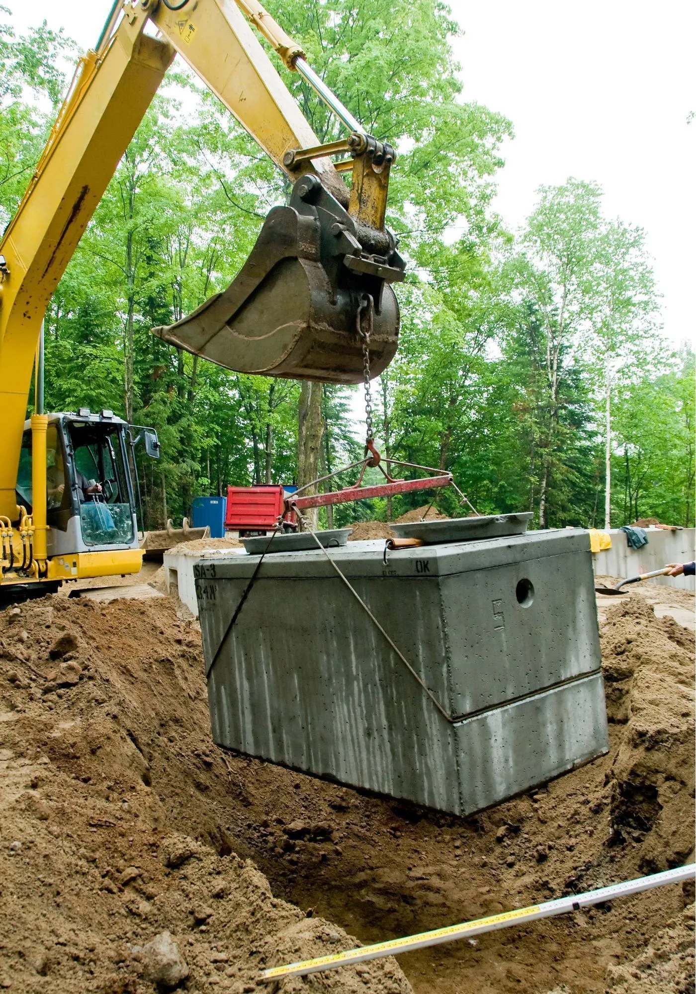 Black plastic water meter, partially buried in a trench, with open lid and connecting pipes. Black plastic water meter, partially buried in a trench, with open lid and connecting pipes.